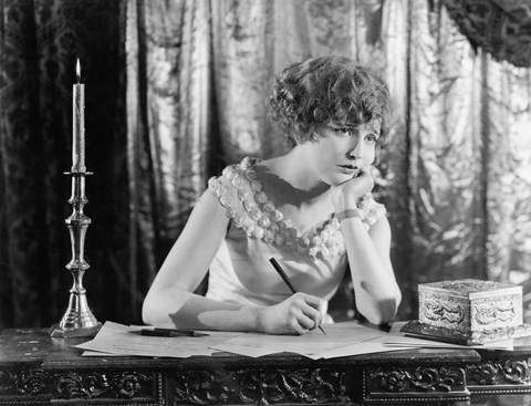 Young woman at her desk writing.